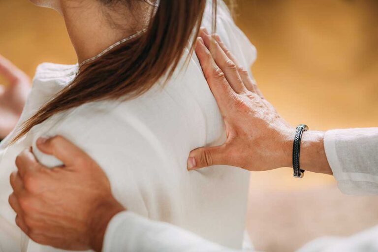 Person seated at a desk gently stretching the neck and shoulders during a break.